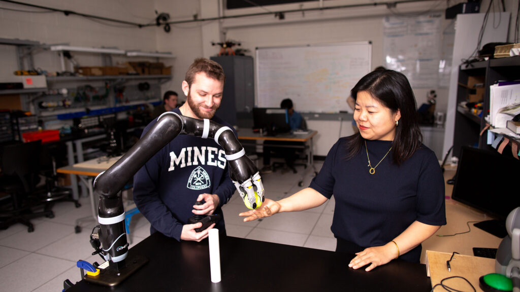 Two students working with robotic synthetic parts