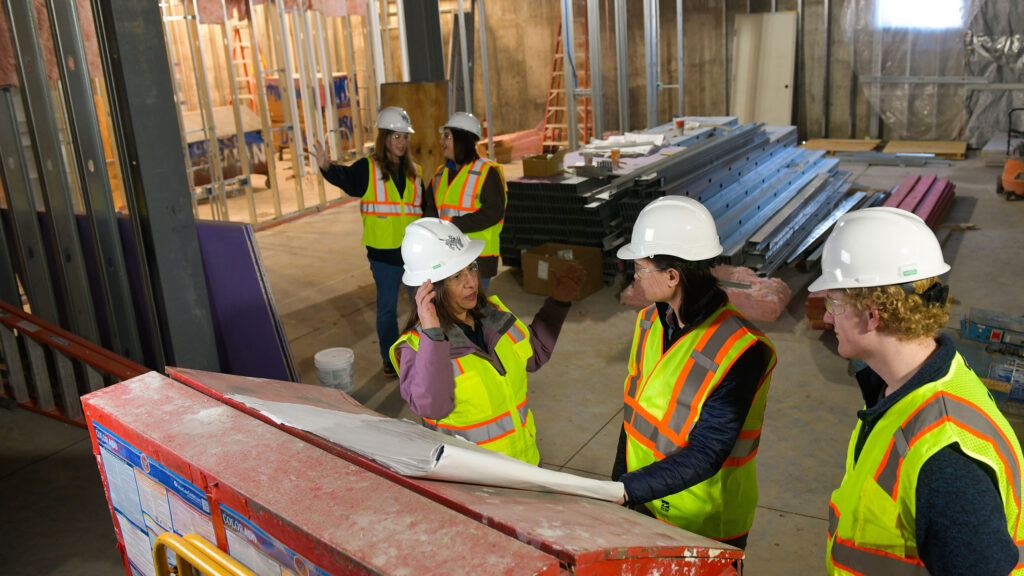 Students discussing techniques at a construction site